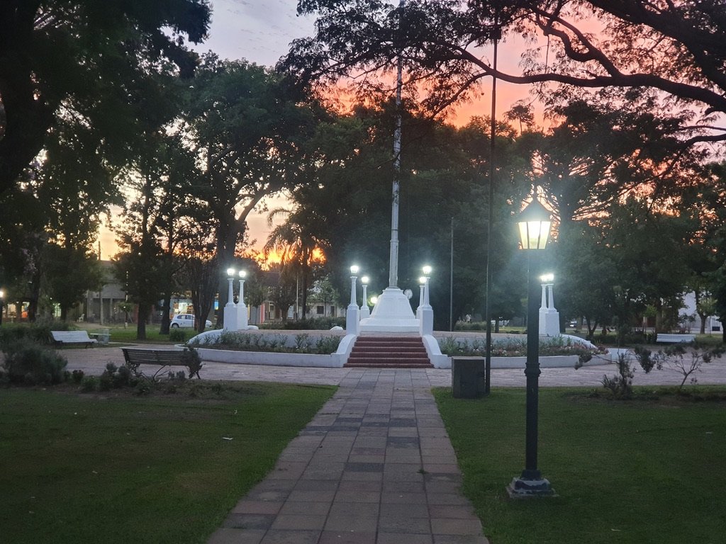 Plaza principal de Salto Grande, Santa Fe, con senderos, bancos y árboles al atardecer. Foto: Obazan, 2021; Wikimedia Commons.